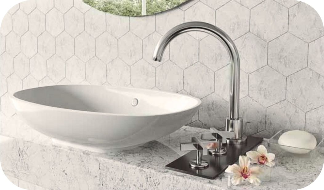 Baterija za lavabo postavljena uz nadgradni umivaonik na kamenoj ploči.