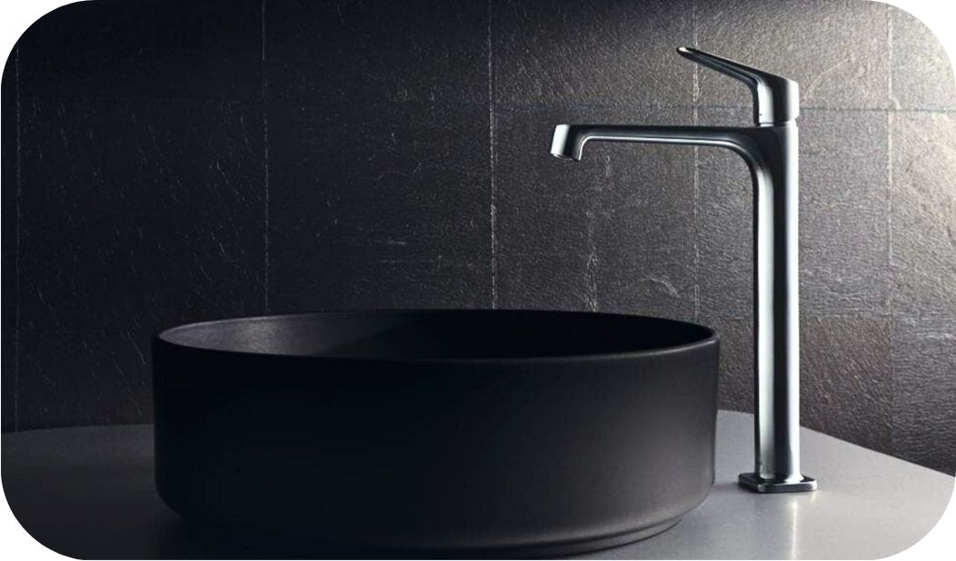 Visoka baterija za lavabo uz nadgradni crni umivaonik – primer pravilne proporcije.