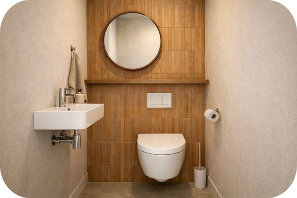 Mali porodični toalet sa rustičnim pločicama u toplim tonovima, zidnim WC-om i malim umivaonikom