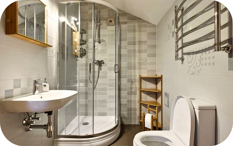 Malo kupatilo sa ugaonom tuš kabinom i svetlim pločicama