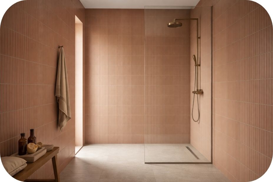 Walk-in tuš kabina sa jednobojnim vertikalnim pločicama koje se nastavljaju izvan i unutar tuš zone